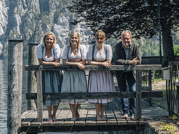 [Translate to Englisch:] Familie Gröller in der Tracht am Steg