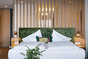 Großzügige Suite mit Doppelbett, Wohnbereich, Sesseln und moderner Einrichtung am Traunsee
