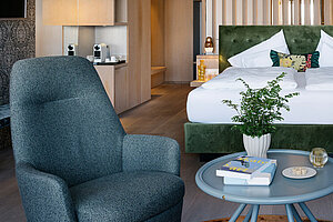 Großzügige Suite mit Doppelbett, Wohnbereich, Sesseln und moderner Einrichtung am Traunsee