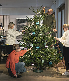 Familie Gröller beim Dekorieren des Weihnachtsbaums