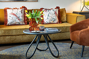 Wohnbereich mit Sofa, Sessel und Schreibtisch in moderner Suite am Traunsee
