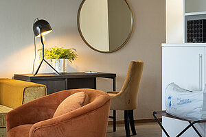 Wohnbereich mit Sofa, Sessel und Schreibtisch in moderner Suite am Traunsee