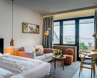 Modernes Hotelzimmer mit Seeblick am Traunsee, Balkon, Sofa, Schreibtisch und stilvoller Einrichtung