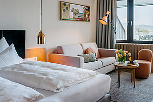 Modernes Hotelzimmer mit Seeblick am Traunsee, Balkon, Sofa, Schreibtisch und stilvoller Einrichtung