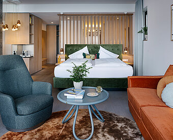 Großzügige Suite mit Doppelbett, Wohnbereich, Sesseln und moderner Einrichtung am Traunsee
