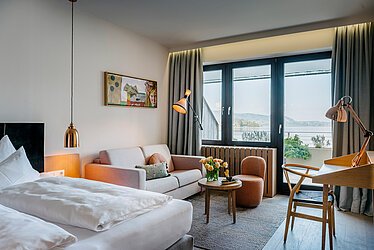 Modernes Hotelzimmer mit Seeblick am Traunsee, Balkon, Sofa, Schreibtisch und stilvoller Einrichtung