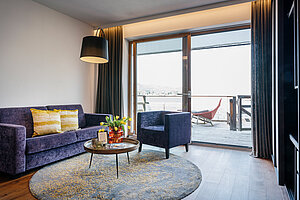 Wohnbereich mit Sofa, Sessel und Balkon mit Seeblick am Traunsee